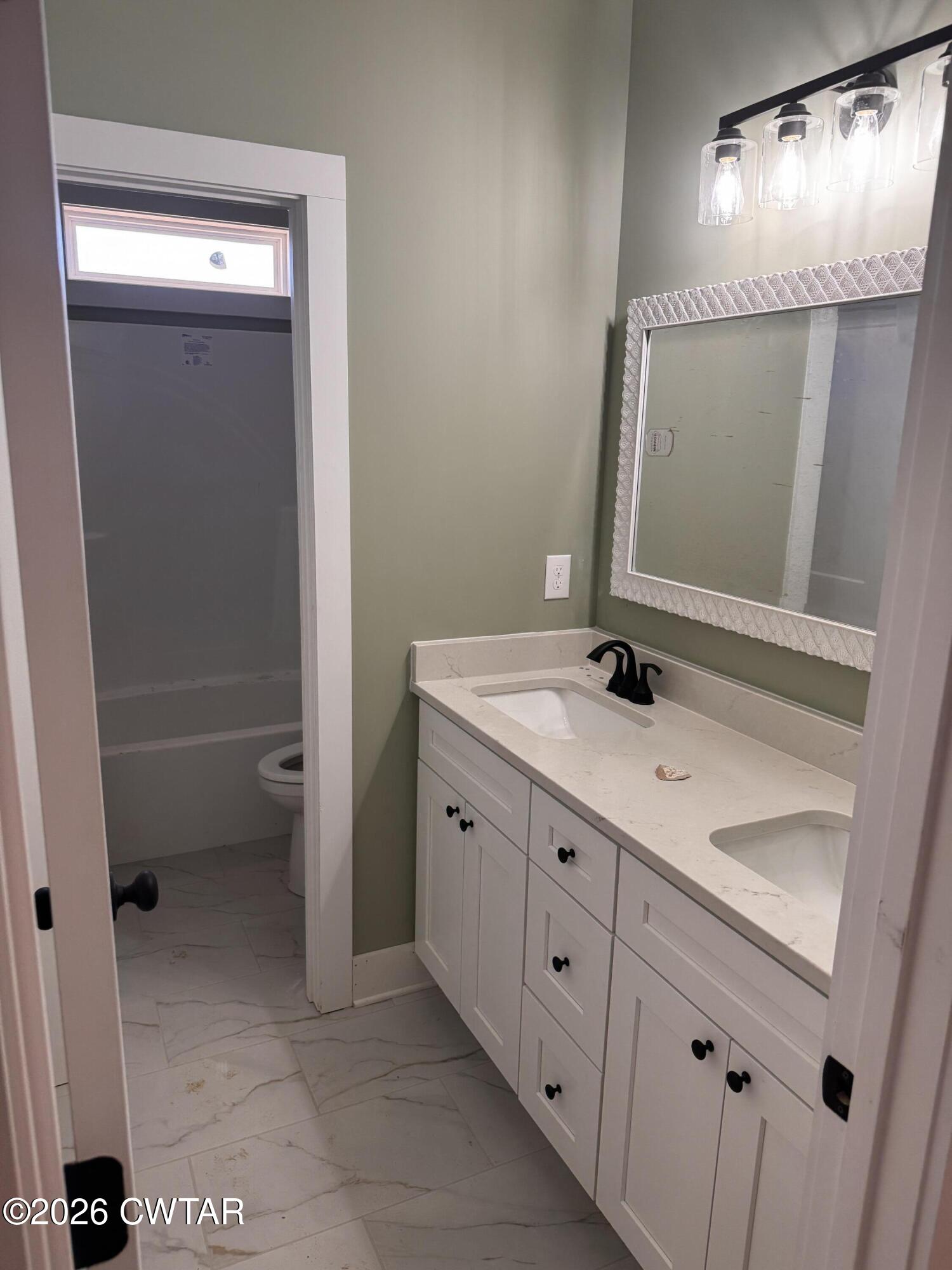 24 Tea Berry Cove Jackson, TN 38305 - Photo 14 of 16 a bathroom with a sink a mirror and a toilet