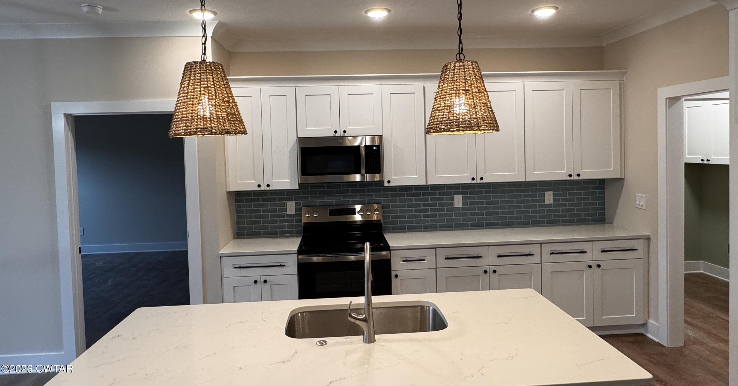 24 Tea Berry Cove Jackson, TN 38305 - Photo 3 of 16 a kitchen with kitchen island white cabinets appliances and a window