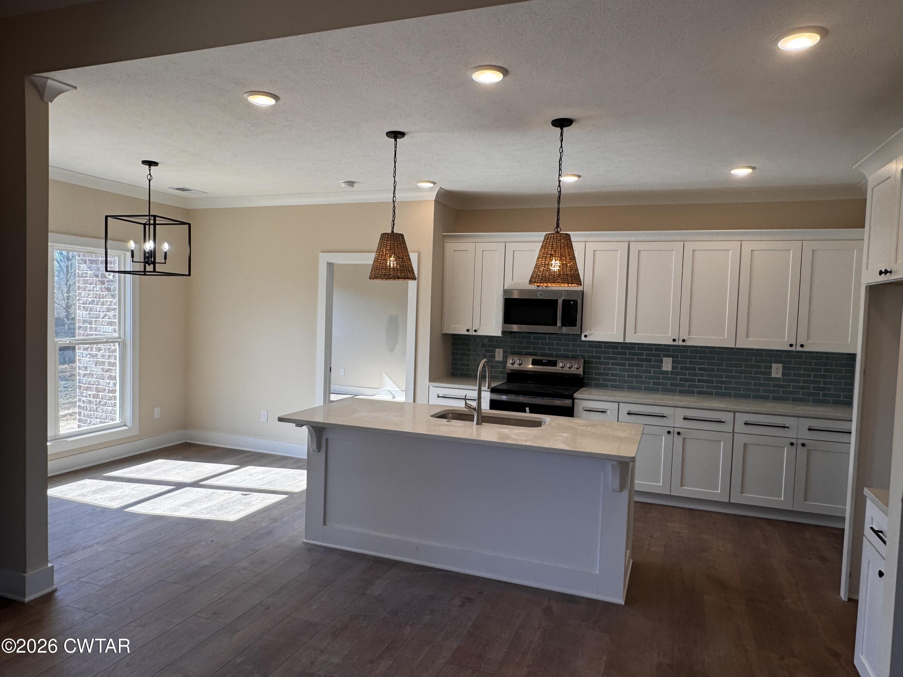 24 Tea Berry Cove Jackson, TN 38305 - Photo 9 of 16 a kitchen with kitchen island a sink stainless steel appliances and cabinets