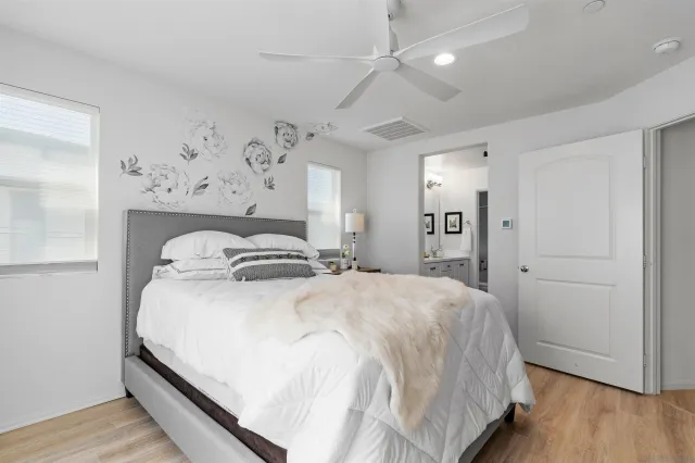 a spacious bedroom with a bed and a wooden floor