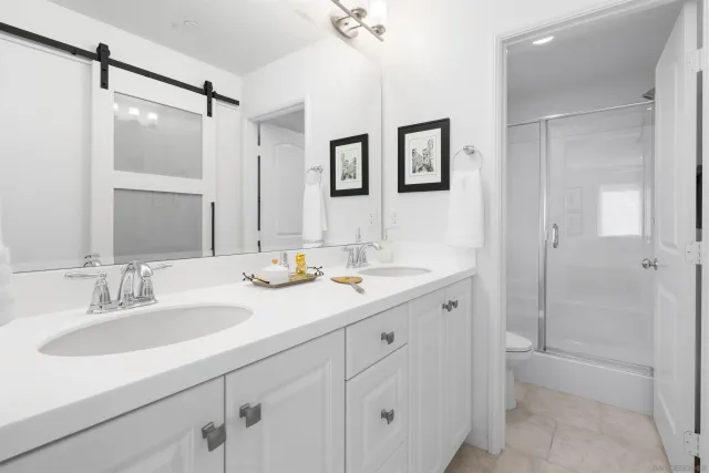 a bathroom with a double vanity sink mirror and shower