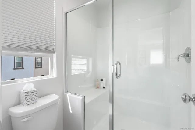 a bathroom with a toilet and a shower