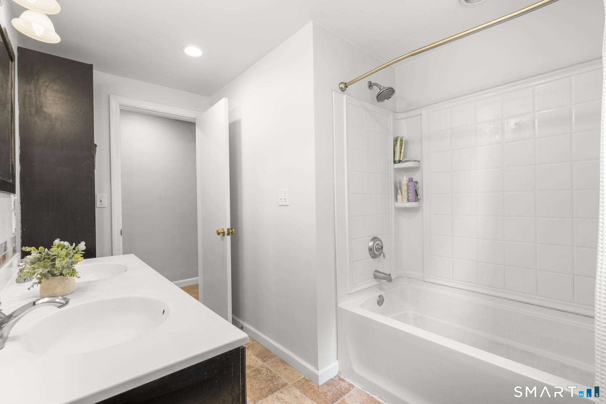 200 Old Huckleberry Road Wilton, CT 06897 - Photo 14 of 24 a bathroom with a bathtub shower sink and a toilet