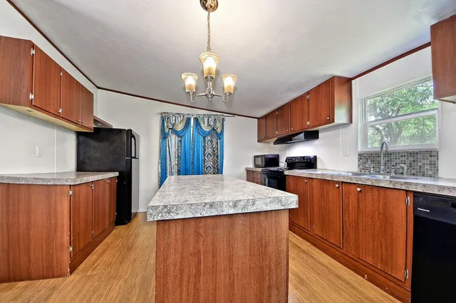 a kitchen with stainless steel appliances granite countertop a stove a sink and a wooden floors