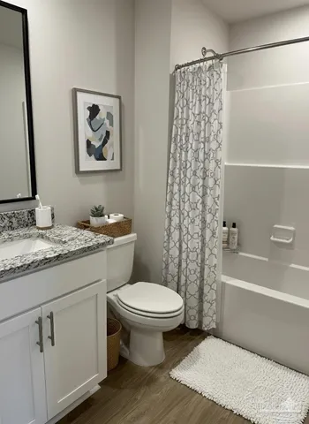 a bathroom with a granite countertop toilet a sink and a bathtub