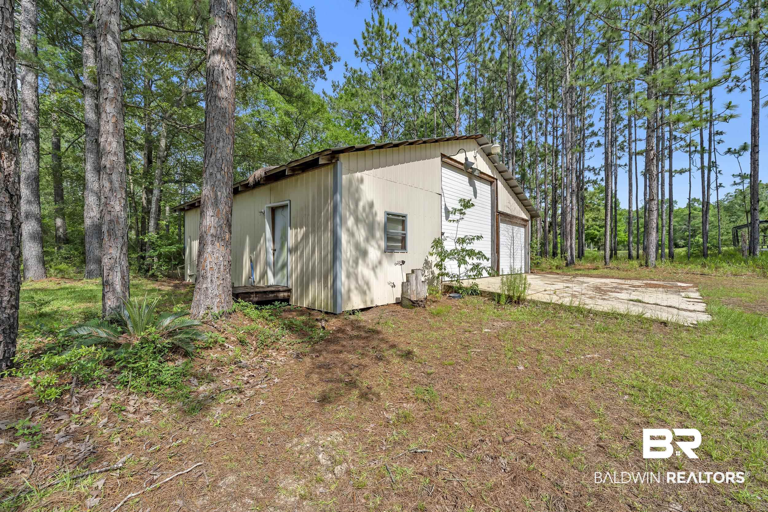14960 Howells Ferry Road Wilmer, AL 36587 - Photo 21 of 22 Freestanding outbuilding featuring light-colored siding and a pitched roof