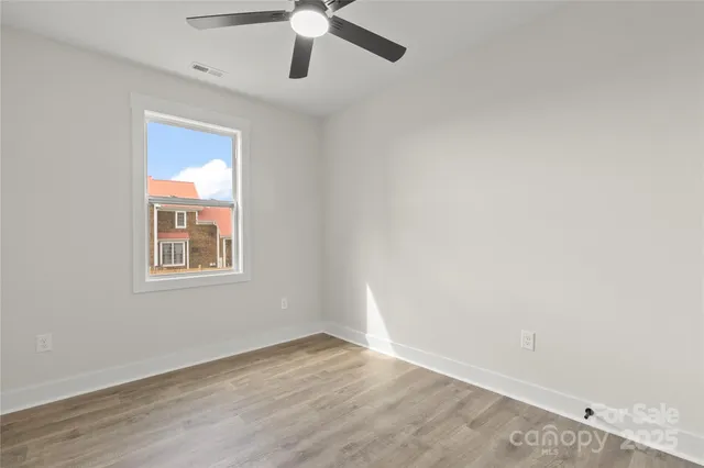 an empty room with a window and a ceiling fan