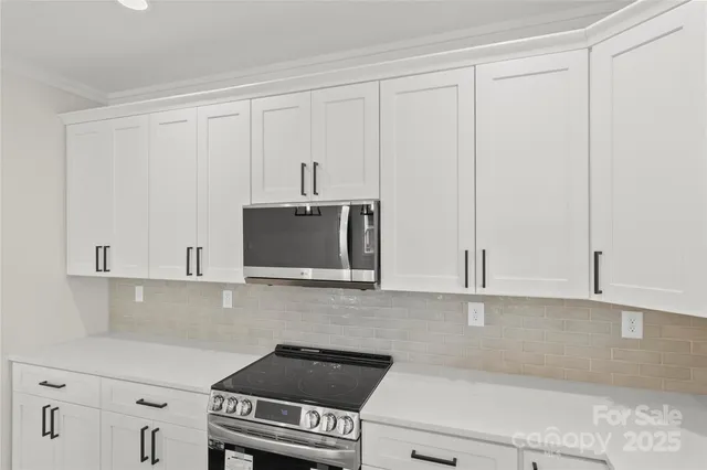 a kitchen with stainless steel appliances white cabinets and a sink