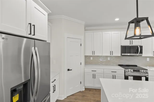 a kitchen with stainless steel appliances granite countertop a refrigerator a stove and a sink