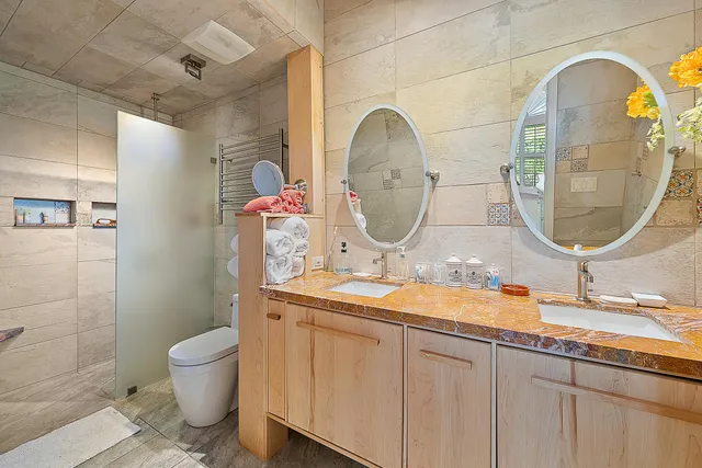 a bathroom with a granite countertop toilet a sink and a mirror