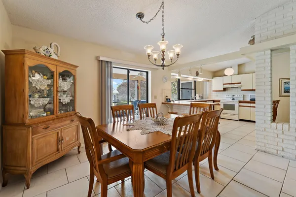 a large kitchen with kitchen island a stove a sink a dining table and chairs