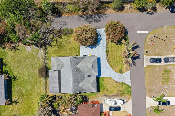 an aerial view of a house with swimming pool and large trees