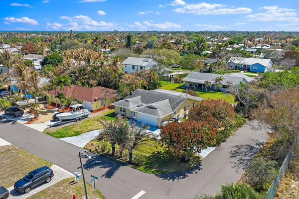 an aerial view of residential houses with outdoor space and trees