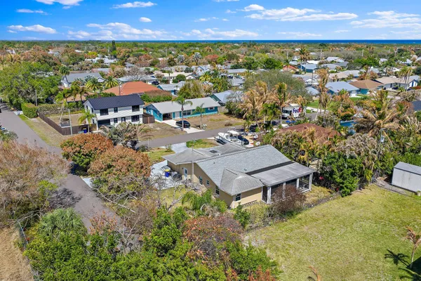 an aerial view of residential houses with outdoor space and trees