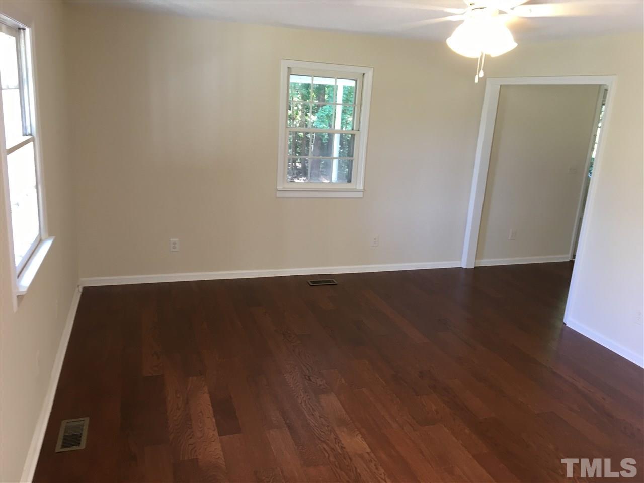 689 Silas Moore Road Coats, NC 27521 - Photo 2 of 17 an empty room with wooden floor and windows