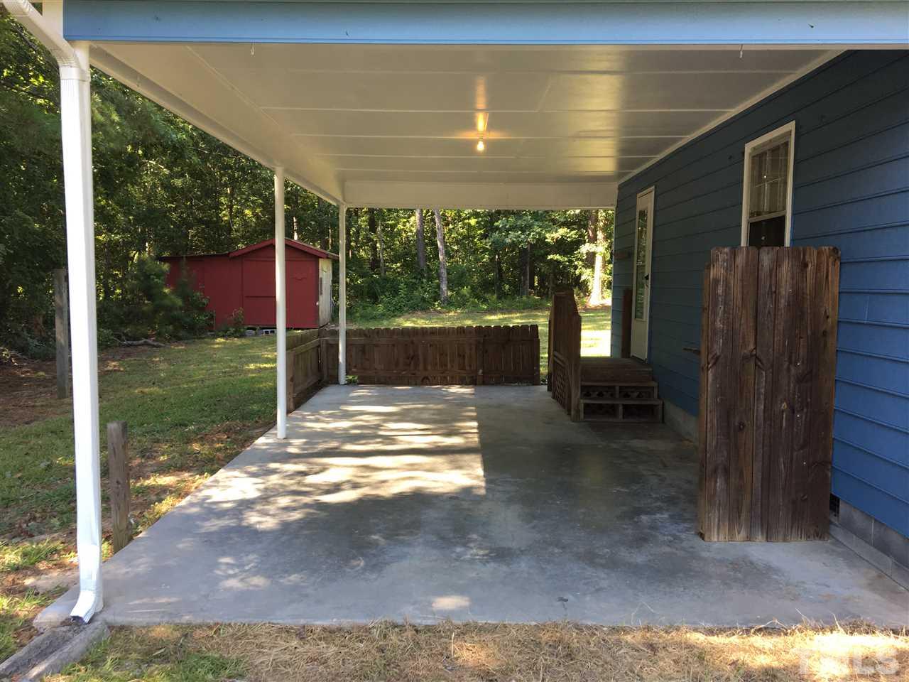 689 Silas Moore Road Coats, NC 27521 - Photo 16 of 17 a view of a porch with a floor to ceiling window and a yard