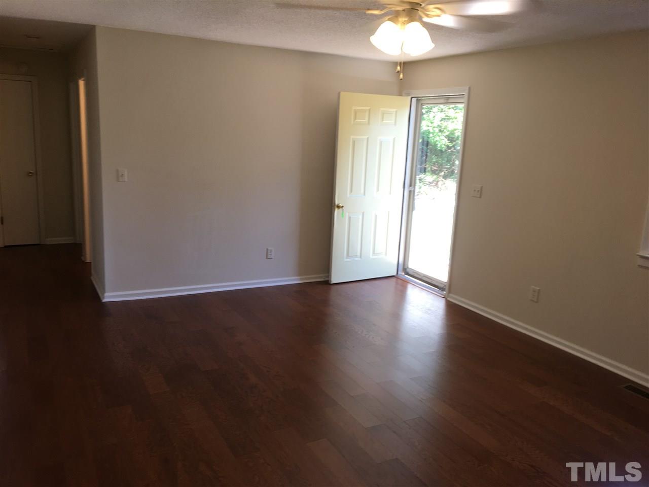 689 Silas Moore Road Coats, NC 27521 - Photo 4 of 17 an empty room with wooden floor and windows