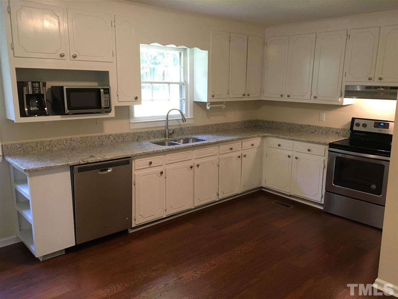 689 Silas Moore Road Coats, NC 27521 - Photo 5 of 17 a kitchen with granite countertop white cabinets stainless steel appliances and a sink