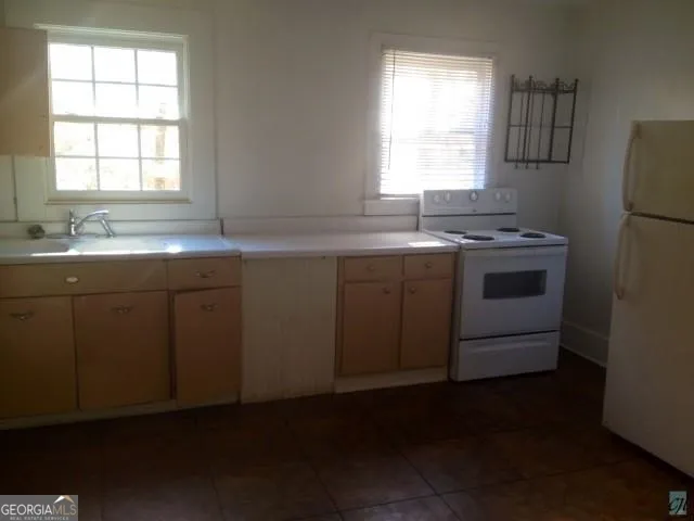 a kitchen with a sink stove and cabinets