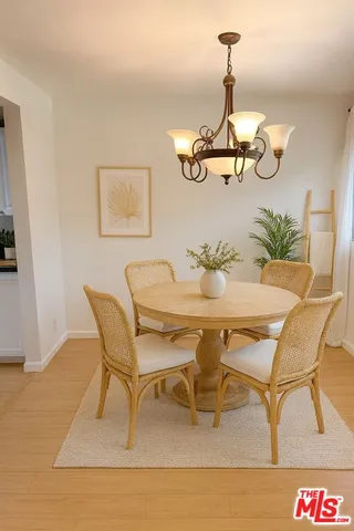 a dining room with wooden floor a chandelier a wooden table and chairs