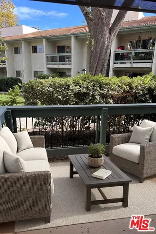 a view of a patio with couches table and chairs and potted plants