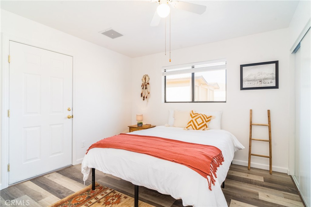61191 Wilson Terrace Joshua Tree, CA 92252 - Photo 14 of 29 a bedroom with a bed a mirror and a window