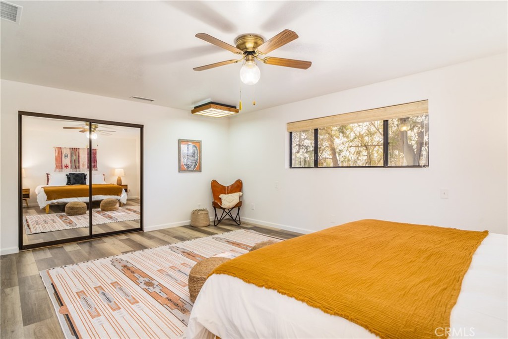 61191 Wilson Terrace Joshua Tree, CA 92252 - Photo 18 of 29 a bedroom with a bed and wooden floor