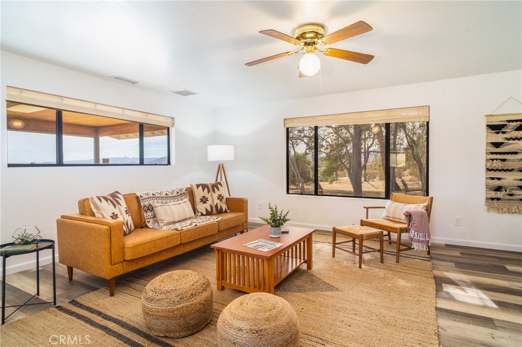 61191 Wilson Terrace Joshua Tree, CA 92252 - Photo 8 of 29 a living room with furniture a chandelier and a large window