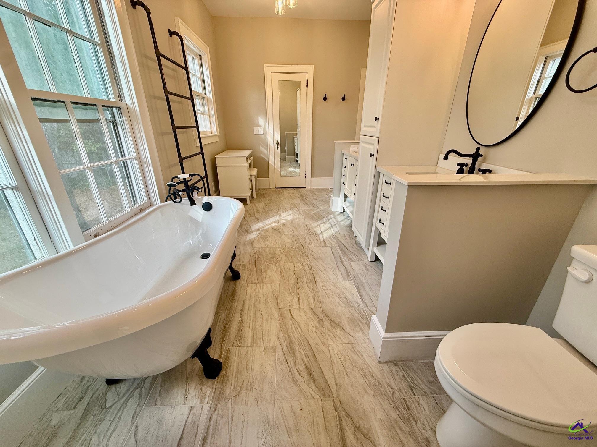 515 Engram Street Montezuma, GA 31063 - Photo 19 of 35 a bathroom with a sink a toilet a mirror and a bathtub
