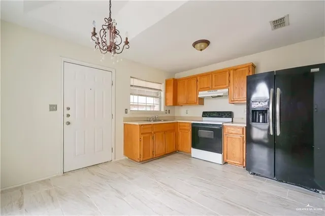 a kitchen with stainless steel appliances granite countertop a refrigerator a sink dishwasher a stove with wooden cabinets and floor