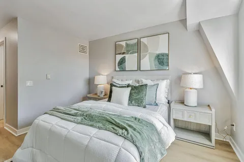 a bedroom with a bed and a painting on the wall