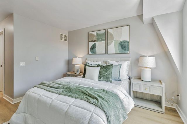 a bedroom with a bed and a painting on the wall