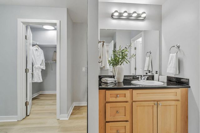 a bathroom with a granite countertop sink and a mirror