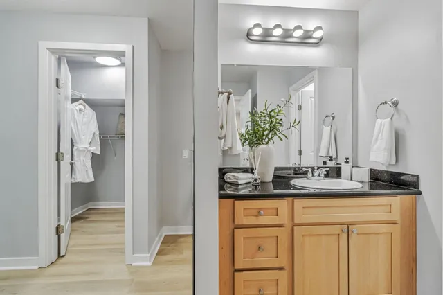 a bathroom with a granite countertop sink and a mirror