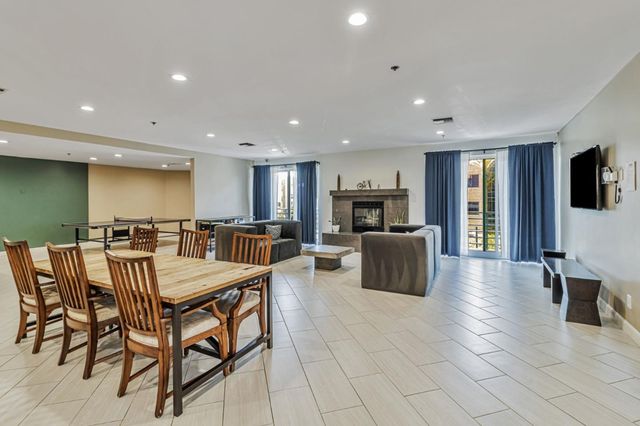 a dining hall with stainless steel appliances a dining table and chairs