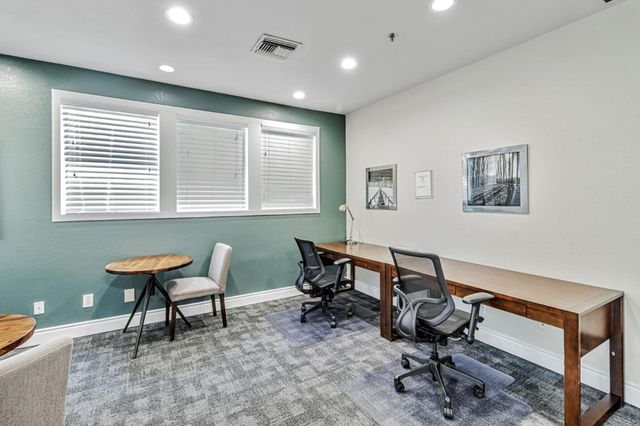 a view of a workspace with furniture and a window