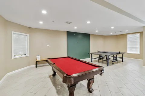 a room with pool table and windows