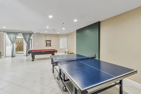 a room with furniture pool table and window