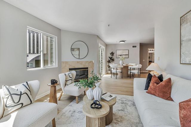a living room with furniture a fireplace and a large window