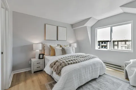 a bedroom with a bed a mirror and a window