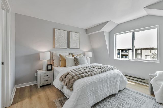 a bedroom with a bed a mirror and a window