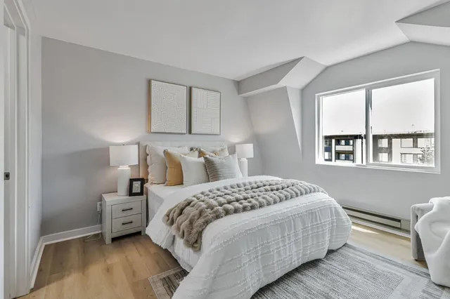 a bedroom with a bed a mirror and a window