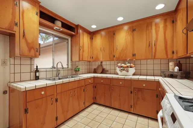 a kitchen with a sink stove top oven and cabinets