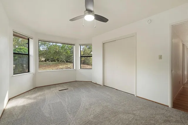 a bathroom with a granite countertop toilet sink and mirror