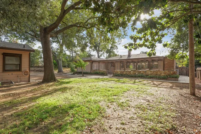 an aerial view of residential houses with outdoor space and trees