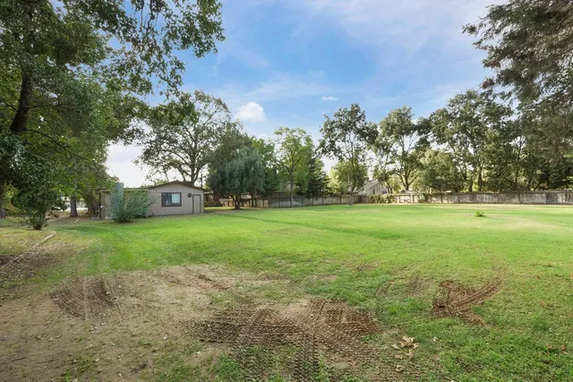 an aerial view of residential house with outdoor space and trees all around