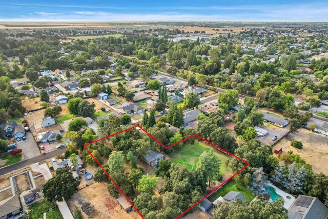 an aerial view of residential house with outdoor space and trees all around