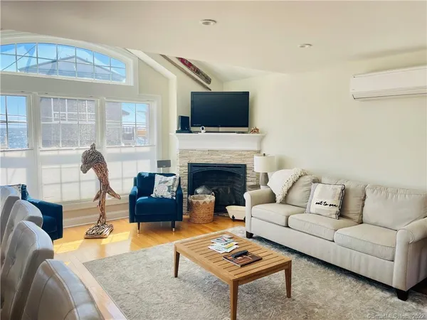 a living room with furniture a flat screen tv and a fireplace