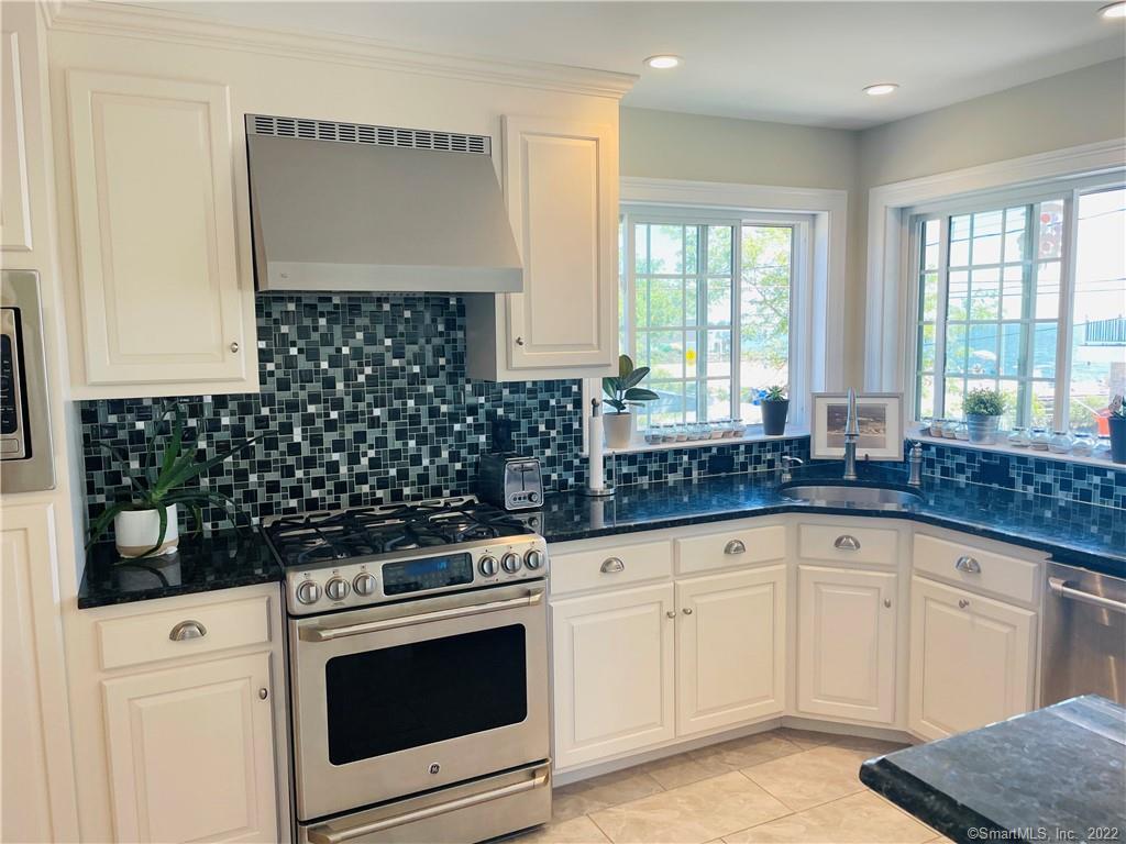 28 Beach Road West Old Saybrook, CT 06475 - Photo 18 of 22 a kitchen with granite countertop white cabinets and white appliances