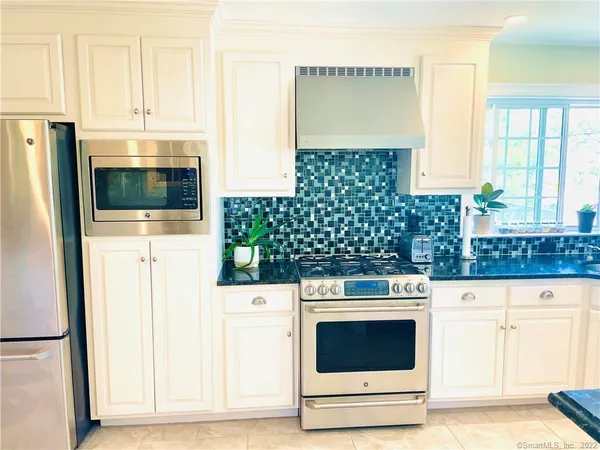 a kitchen with stainless steel appliances a stove and a microwave